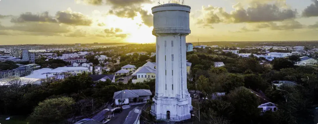 The white Water Tower rising above Nassau's rooftops at sunset.